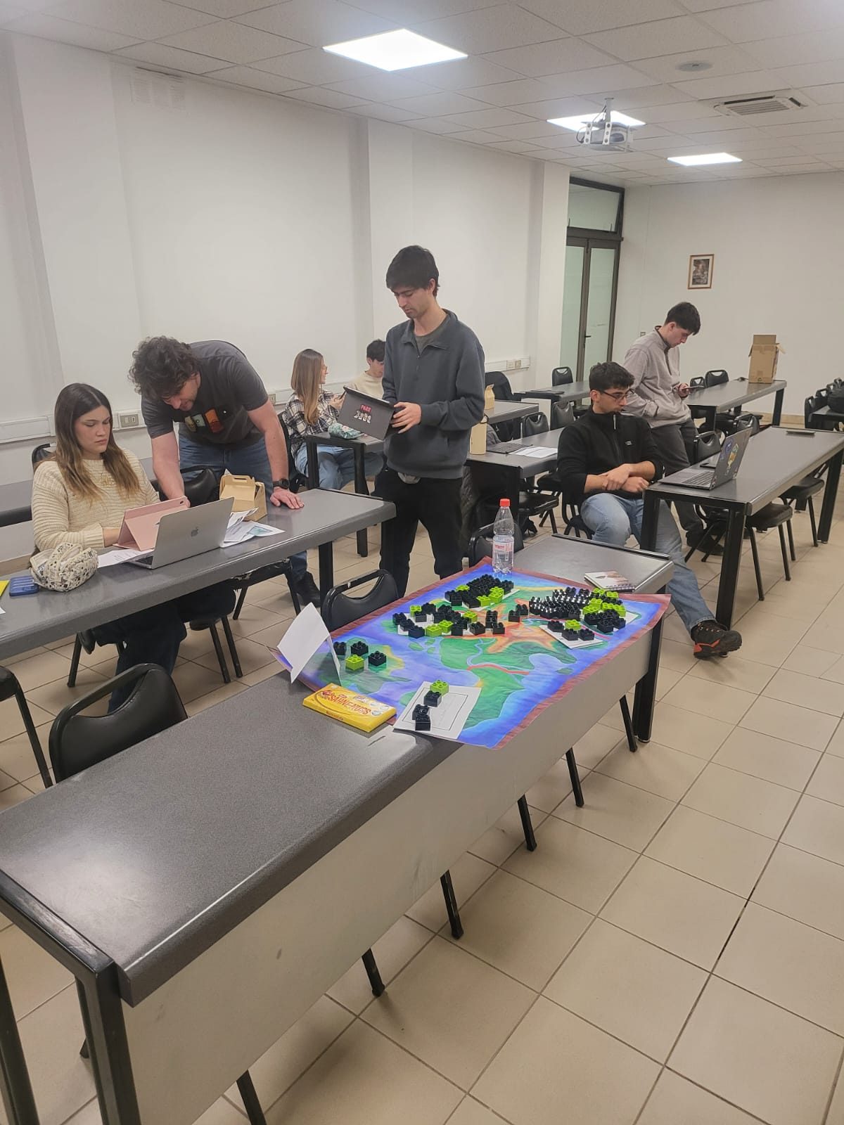 Sesión de Re-conectado en una universidad: estudiantes alrededor del mapa de tela con plantas de LEGO
